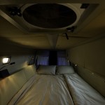 Cozy high bed in Peter's Sprinter conversion.